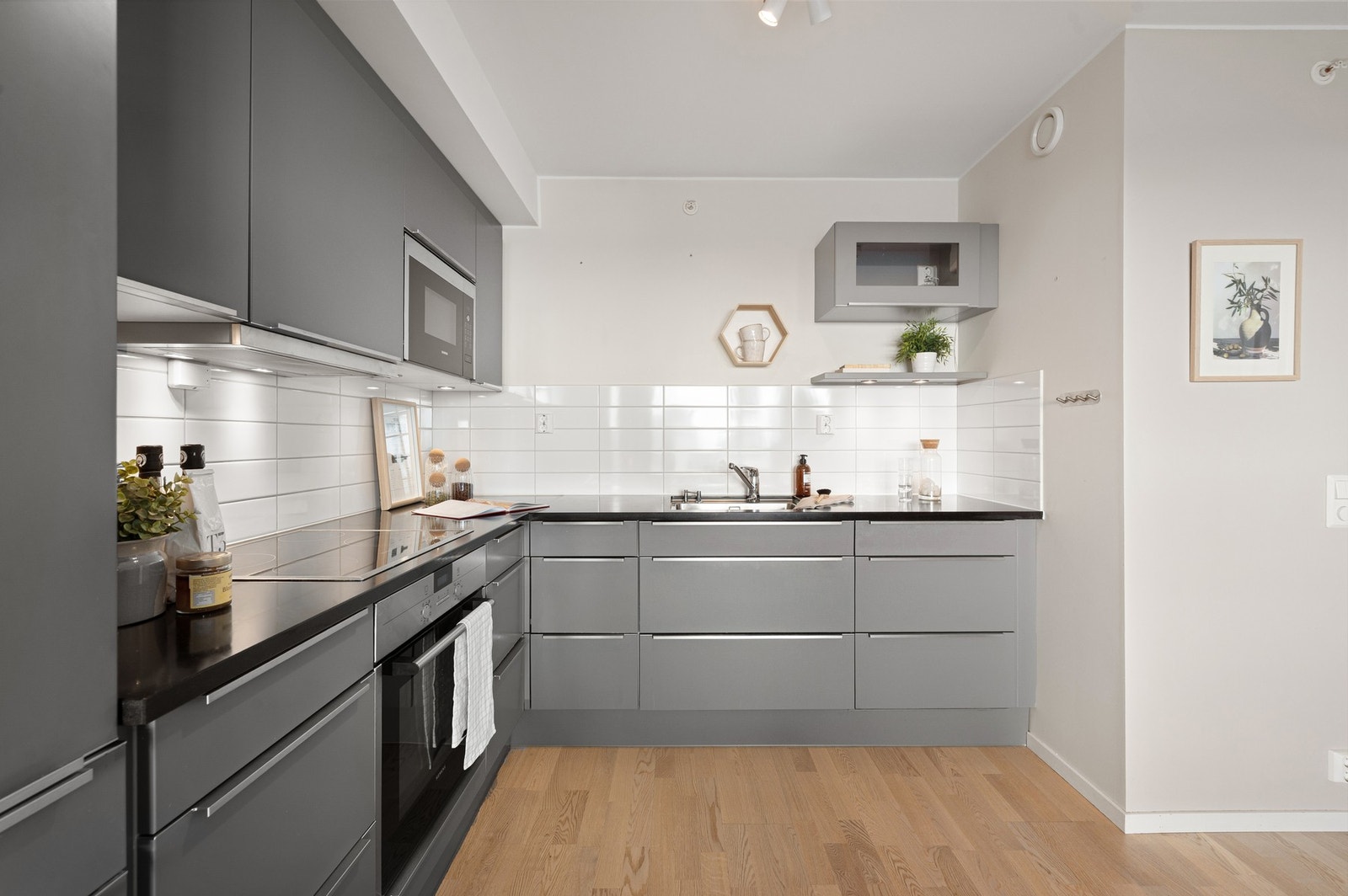 Kjøkkenet er utstyr med integrert platetopp, stekeovn, oppvaskmaskin, mikrobølgeovn og kjøle-/fryseskap. Galleribilde