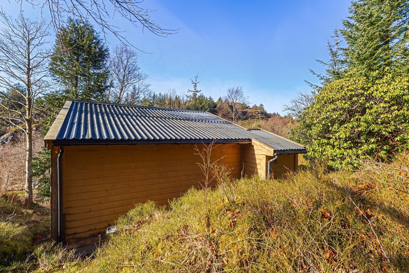 Tomten er skrånende og kupert, med det meste som naturtomt, noe som gir en lun og privat hyttefølelse. Galleribilde