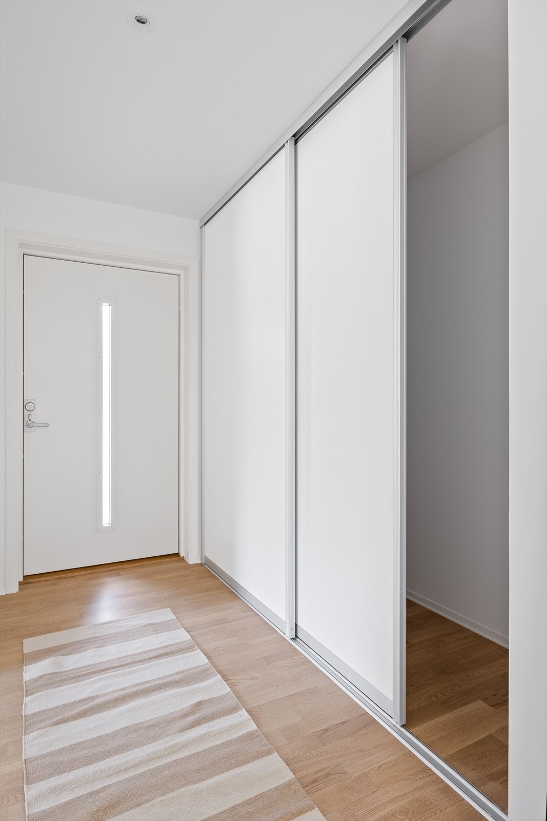 Det er en tiltalende eikeparkett fra Opus, slette gipsvegger malt i moderne farger, samt en stor og fin skyvedørsgarderob Galleribilde