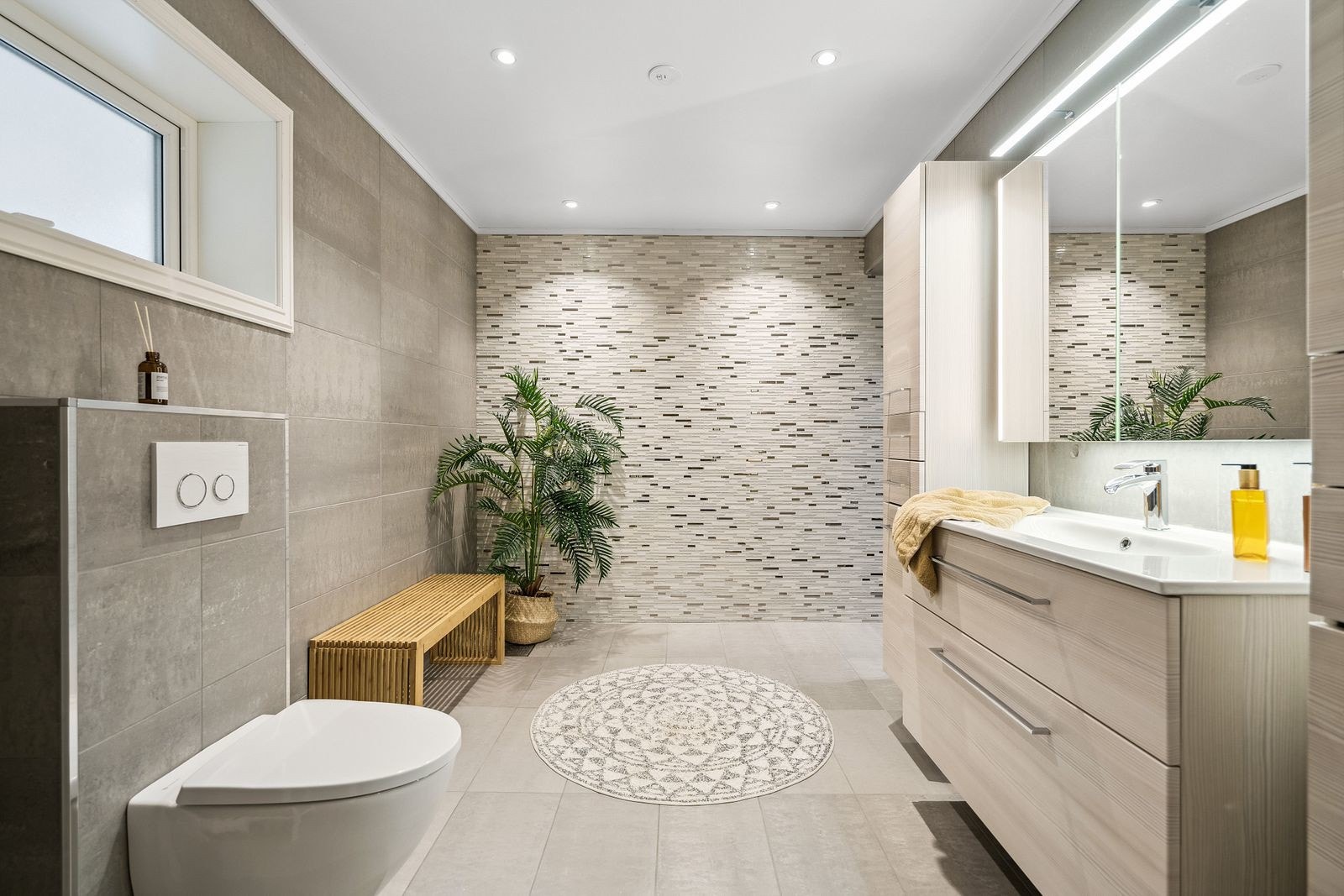 Lekkert flislagt baderom fra 2014. Stor baderomsinnredning for lagring av baderomsartikler. Galleribilde