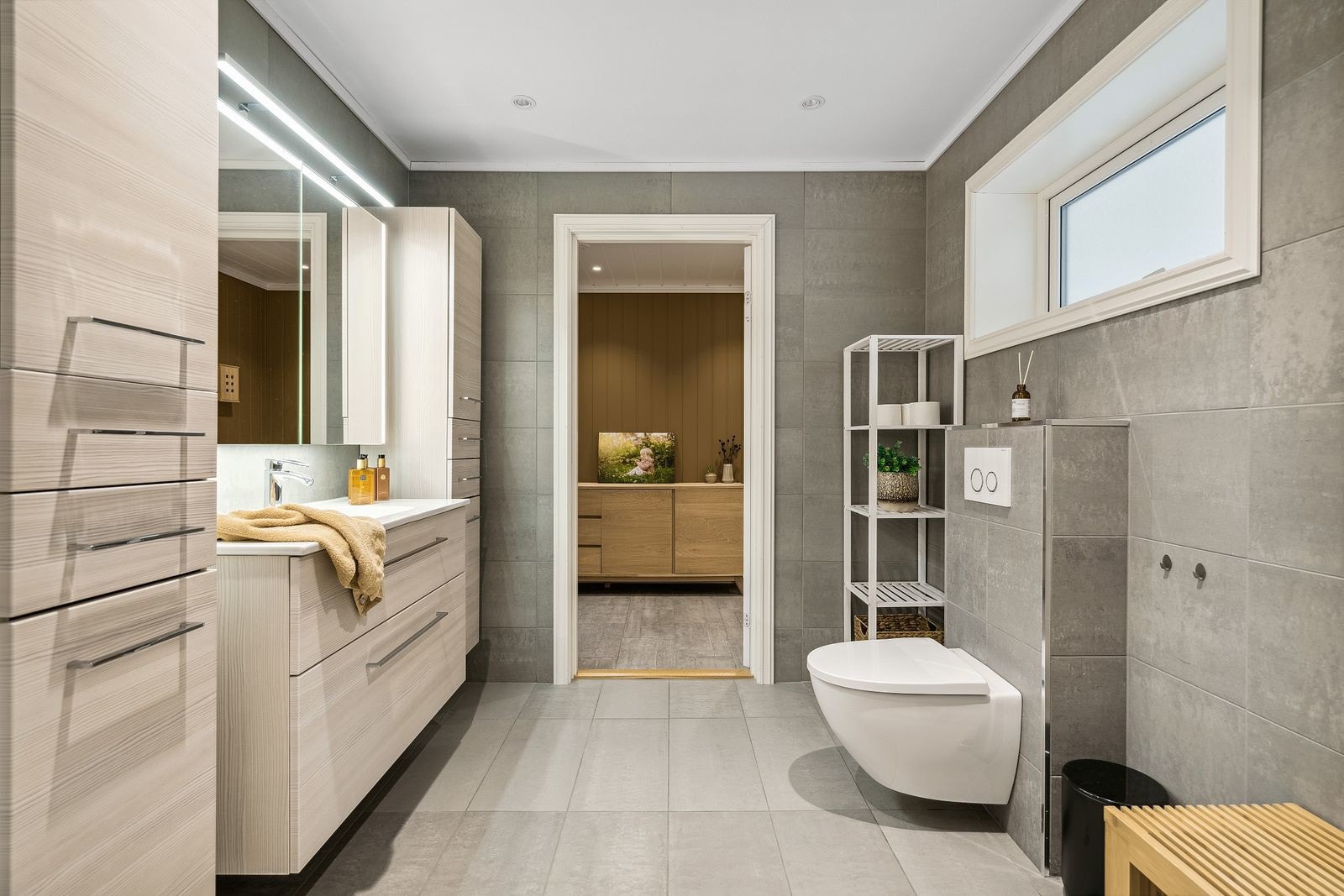 Badet framstår romslig og er utstyrt med praktisk veggmontert toalett, dusjkabinett og downlights i himling. Galleribilde