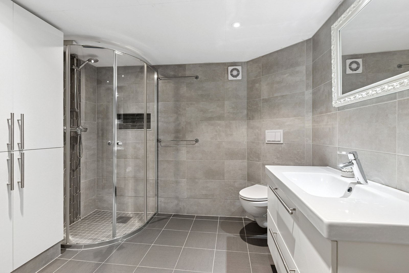 Delikat flislagt bad med diverse oppgraderinger gjort i 2020. Benkeskap og veggskap med glatte fronter, samt dusj med dør i herdet glass (ikke omsøkt/godkjent til varig opphold). Galleribilde