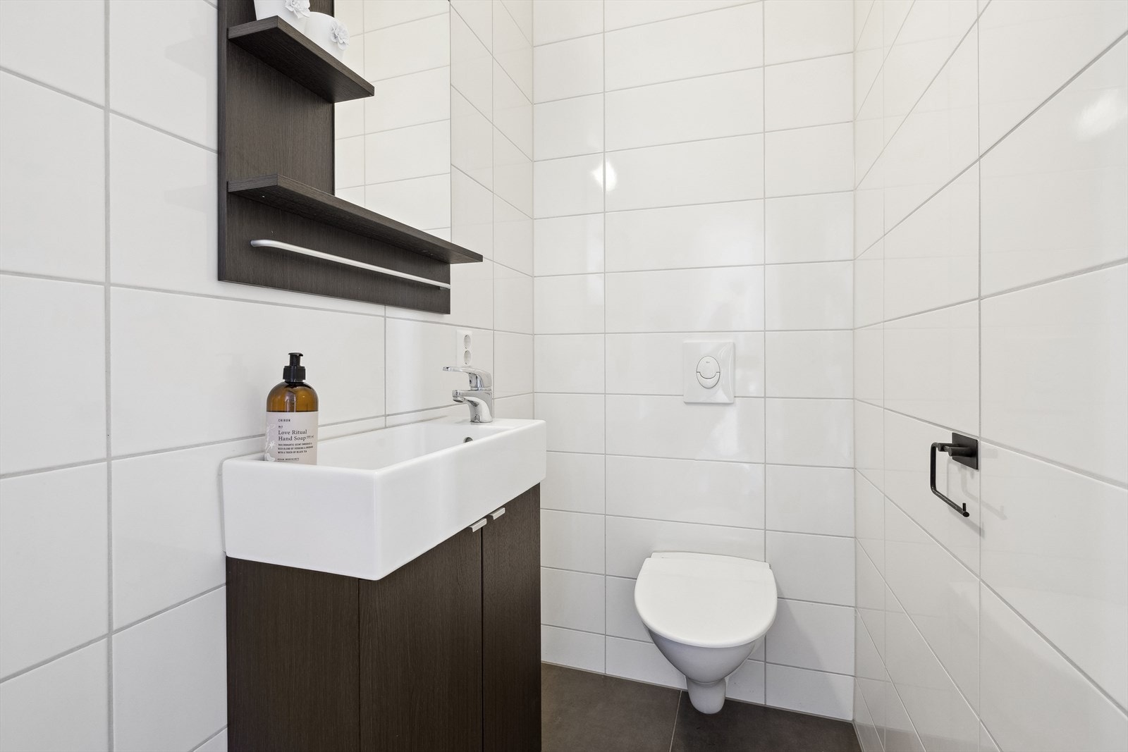 Toalettrom er flislagt og har gulvarme, utstyrt med vegghengt toalett og baderomsinnredning med servant. Galleribilde