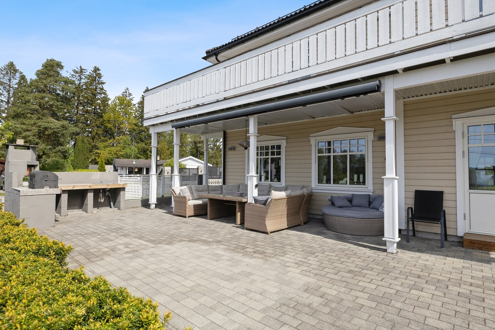 Steinlagt uteplass med eget utekjøkken og peis. Her er det god plass til å innrede i flere soner. Galleribilde