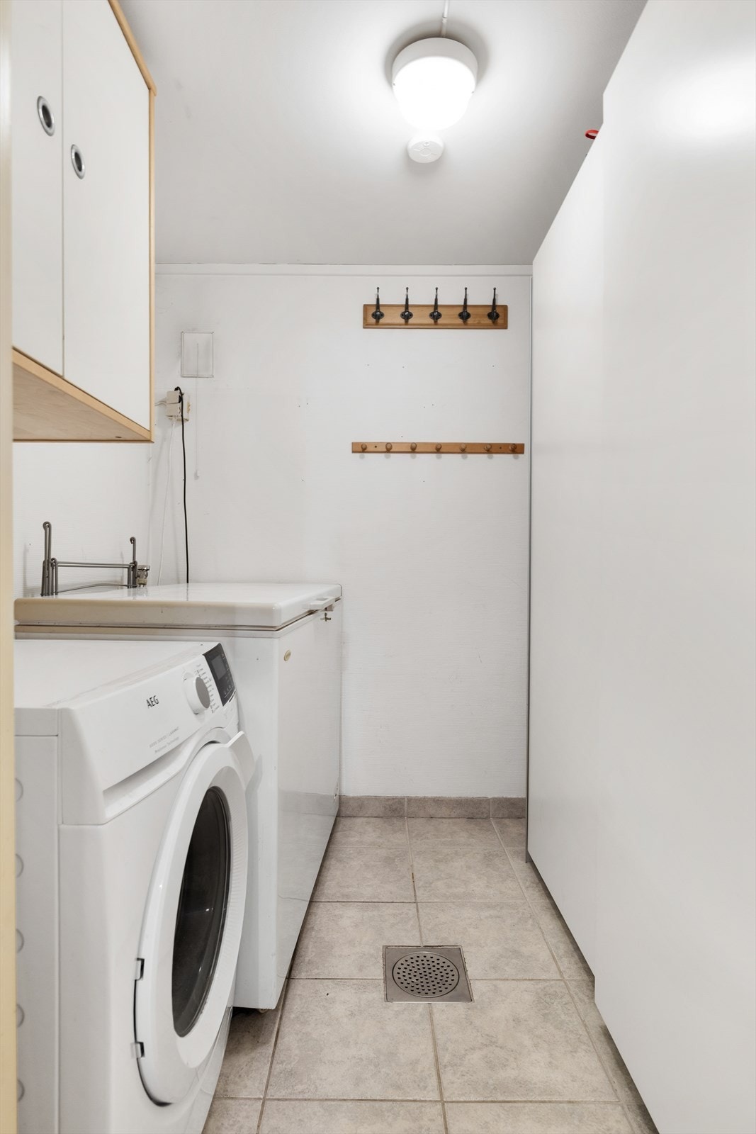 Praktisk vaskerom med fliser på gulvet og god plass til vaskemaskin. Skyvedørsgarderoben følger med. Galleribilde