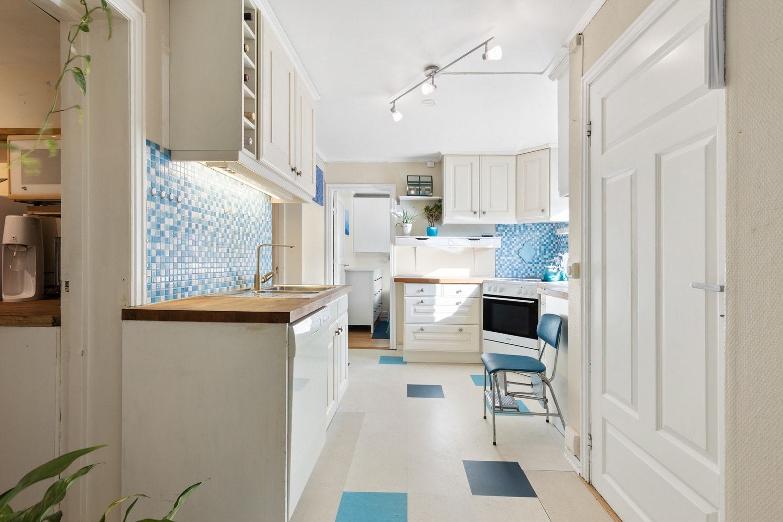 Sjarmerende kjøkken med blå mosaikkdetaljer og benkeplate i tre. Galleribilde