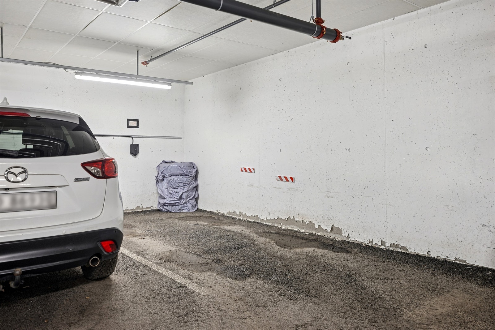 Leiligheten disponerer i en parkeringsplass i kjeller med elbil-lader. Galleribilde