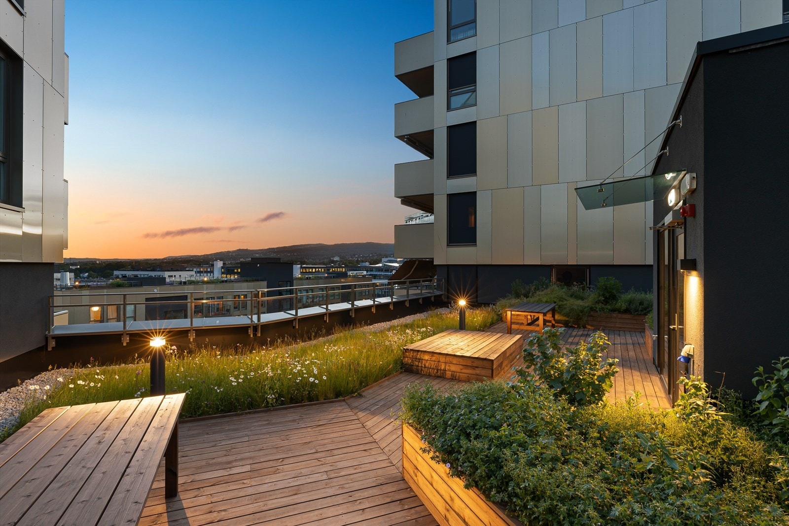 Her kan du nyte sene sommerkvelder og solnedganger. Bildet er av en takterrasse lenger ned i etasjene. Galleribilde