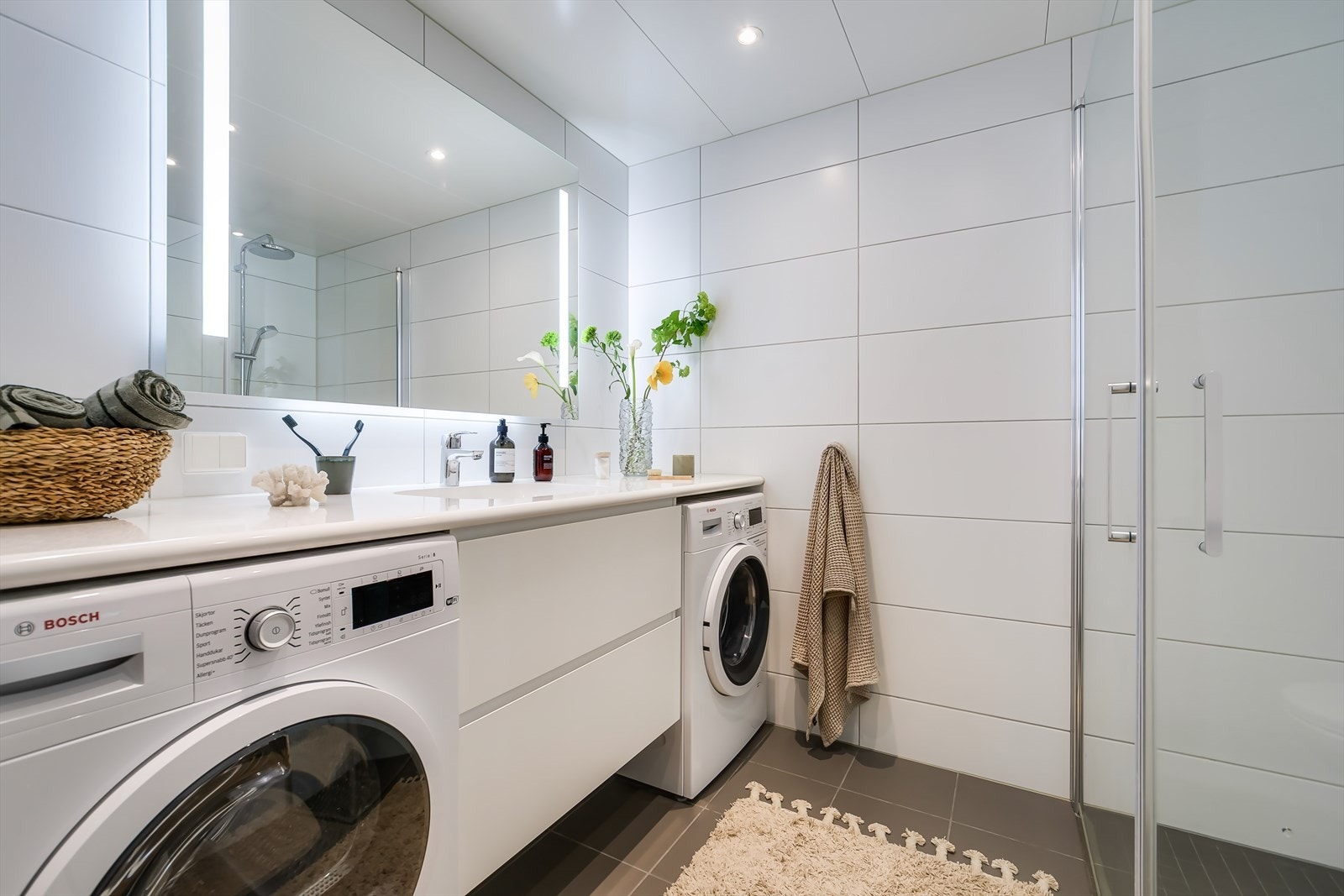 Badet har blant annet servant med innredning, speil med belysning, klosett og dusjhjørne. Galleribilde