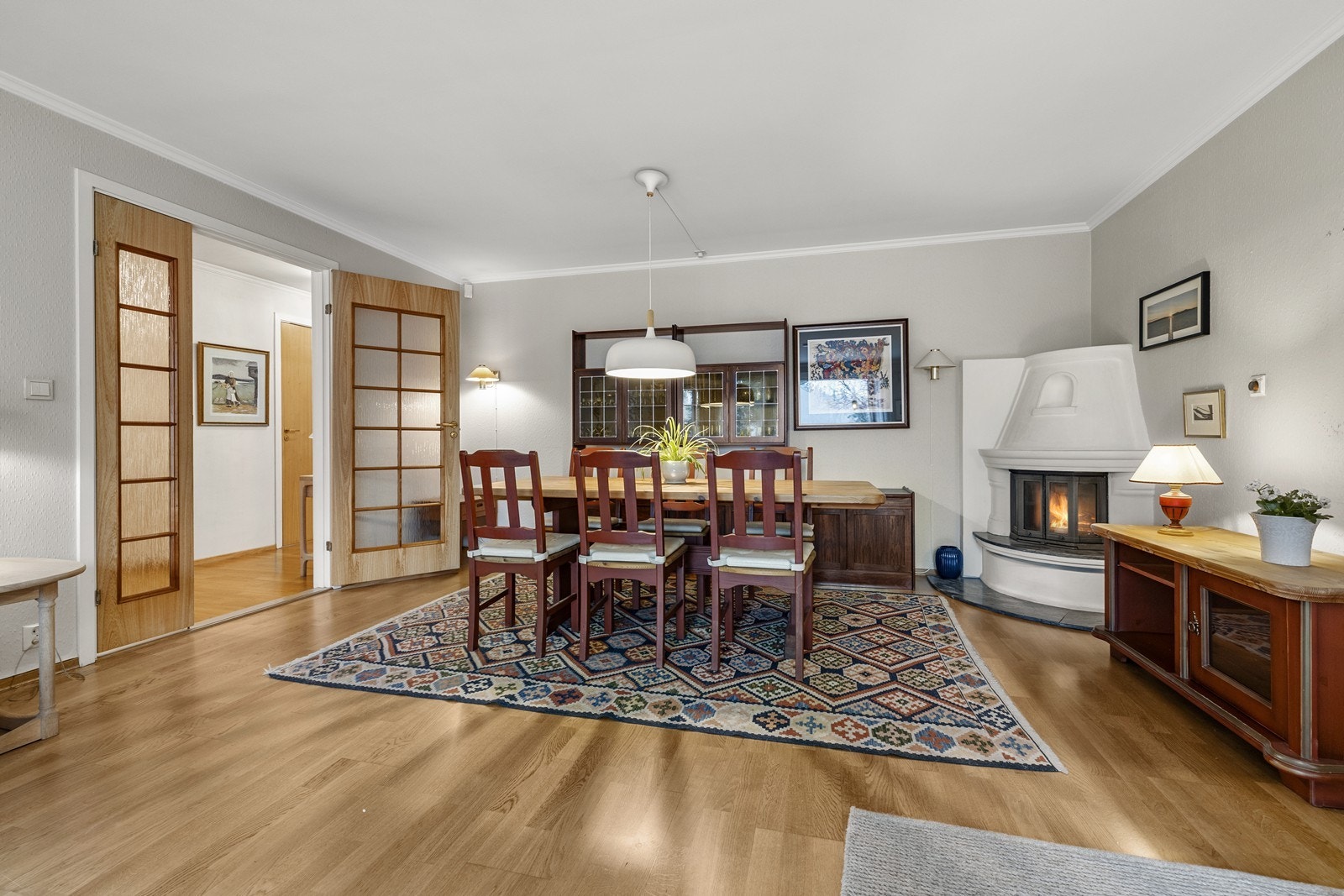 Stuen er leilighetens samlingspunkt, med god plass til spisebord og en peis med innsats som gir lun varme. Galleribilde