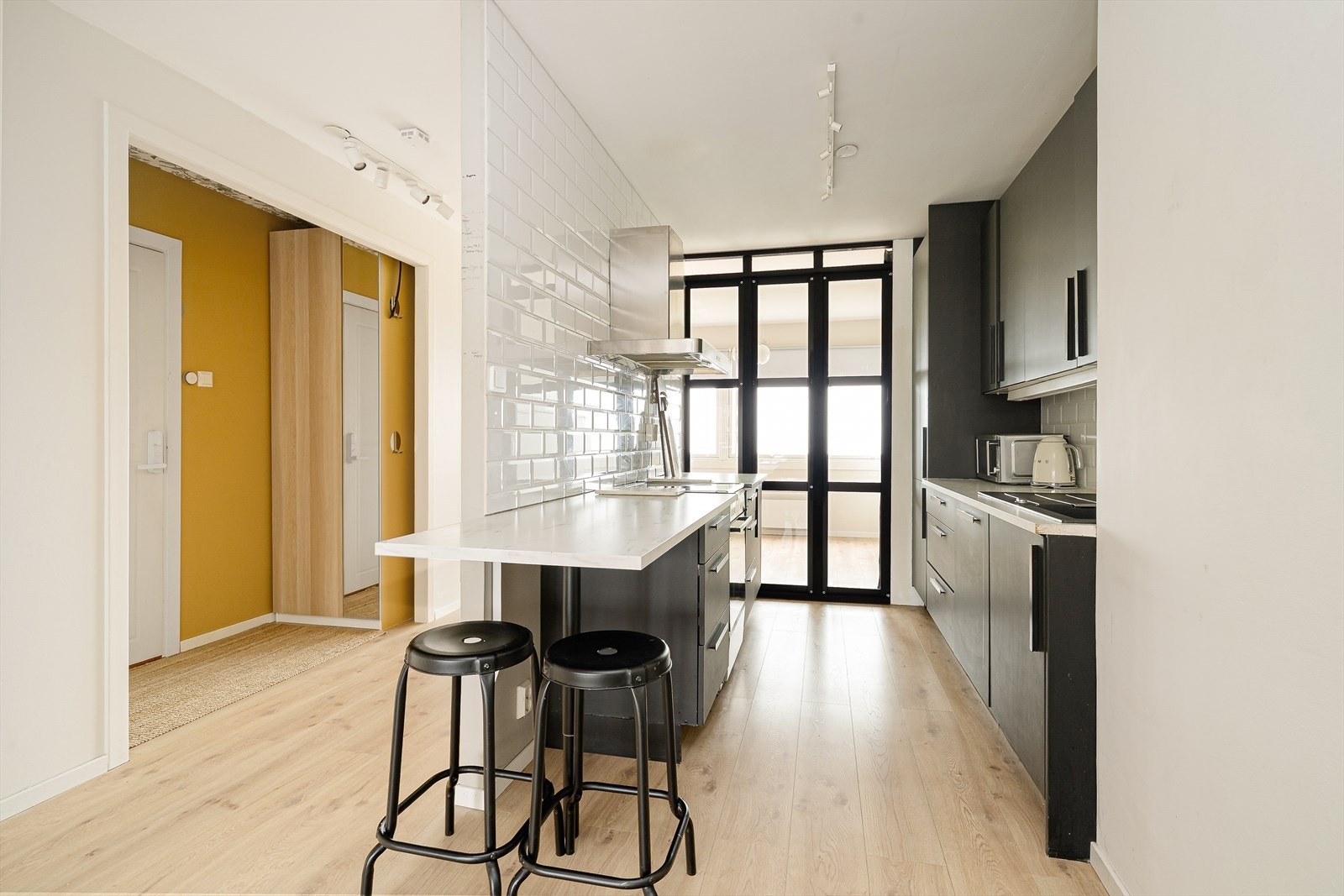 Leiligheten har et moderne kjøkken med god skapplass på to sider, og gode arbeidsflater på benk med frokostplasser på den ene siden. Galleribilde