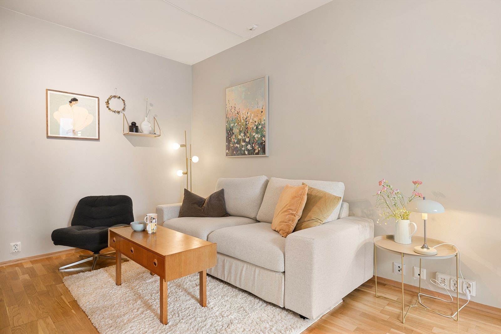 Leilighetens stue fremstår med lyse overflater og parkettgulv som gir et pent uttrykk. Galleribilde