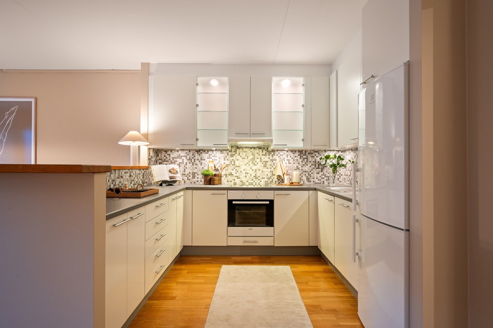 Oppvaskmaskin, platetopp og stekeovn er sømløst integrert i innredningen. Det er montert kjøkkenventilator over kokeplassen. Galleribilde