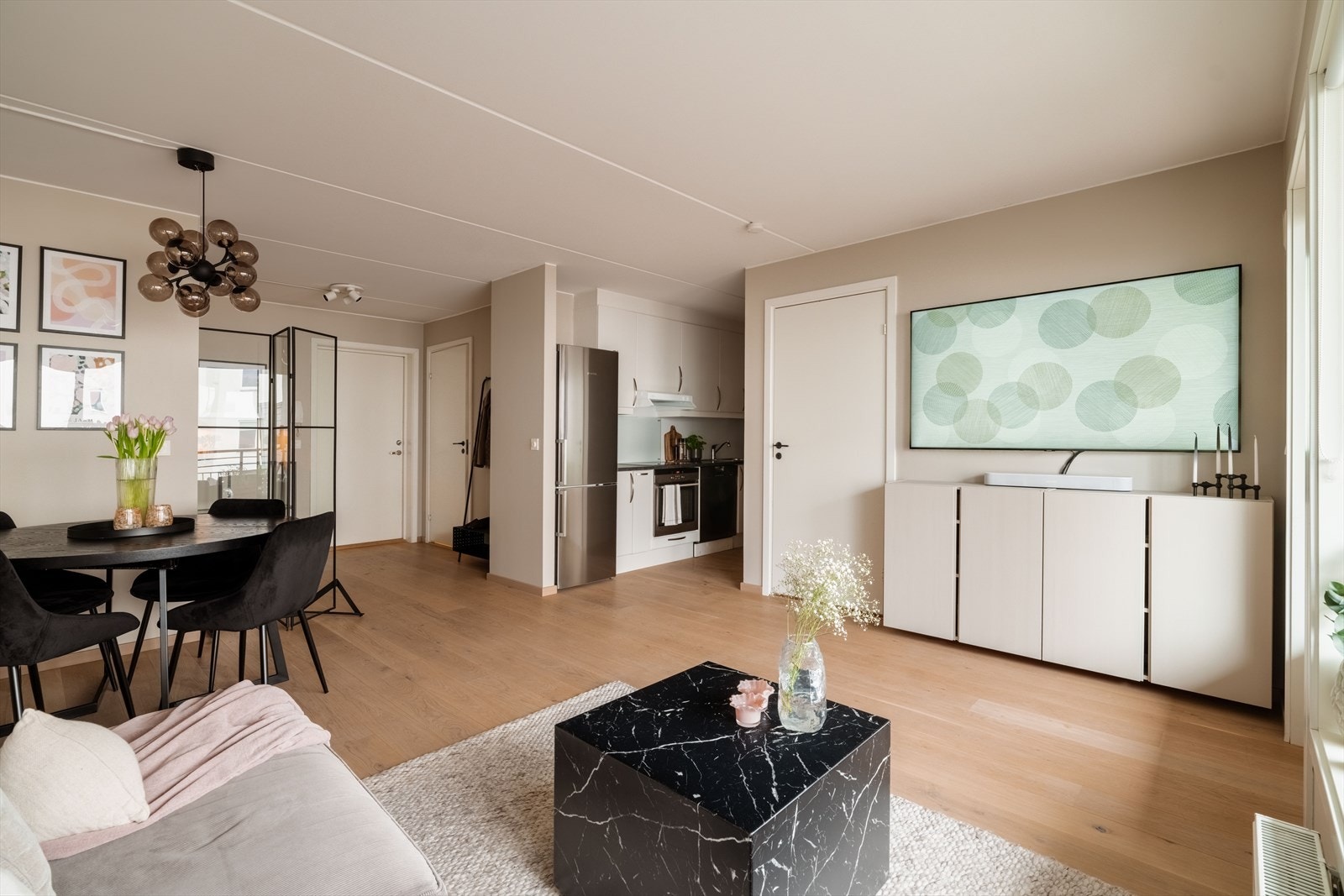 En åpen og sosial sone som binder sammen stue, spiseplass og kjøkken. Galleribilde