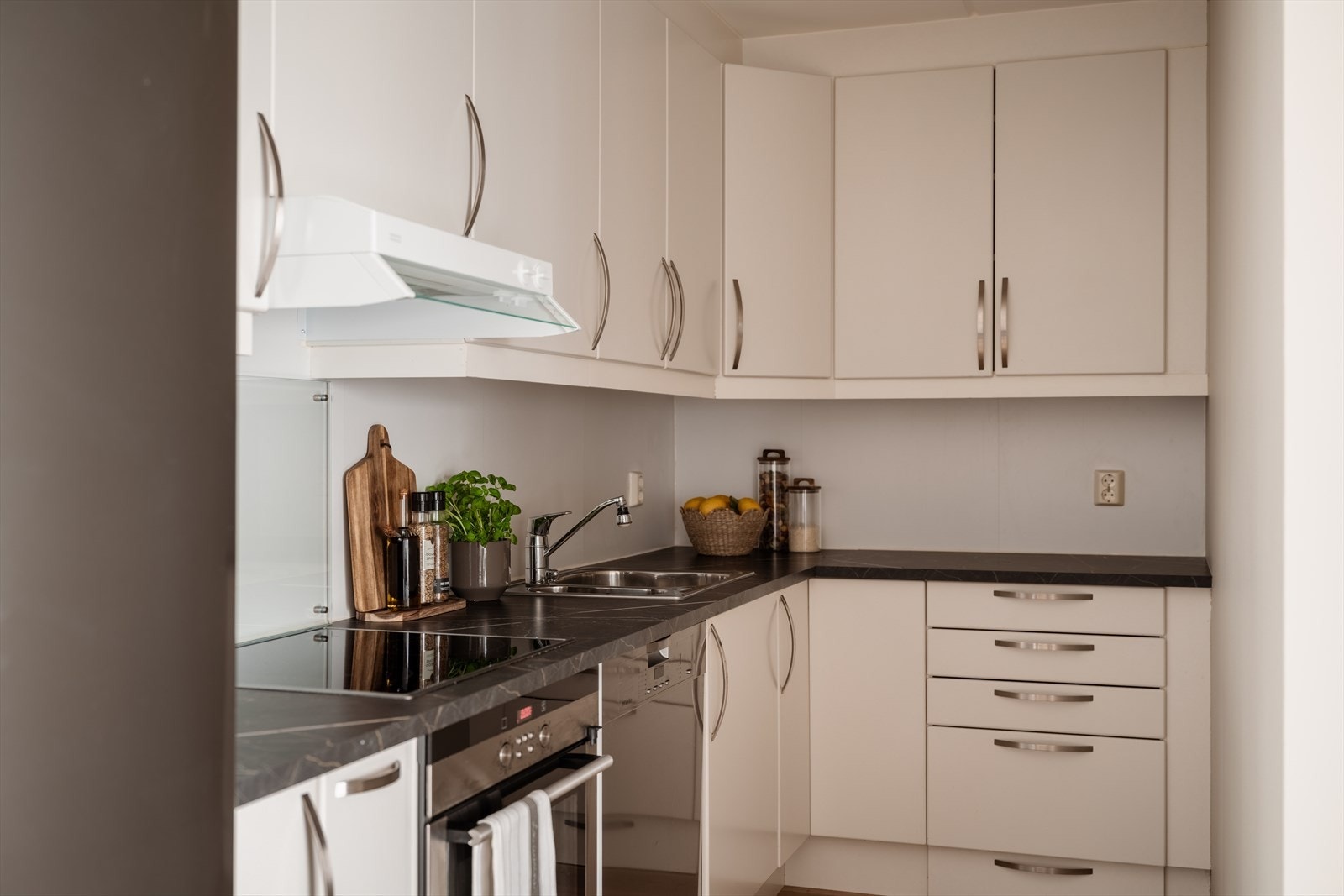 Kjøkkenet har en praktisk innredning med glatte fronter, integrert stekeovn og platetopp. Galleribilde