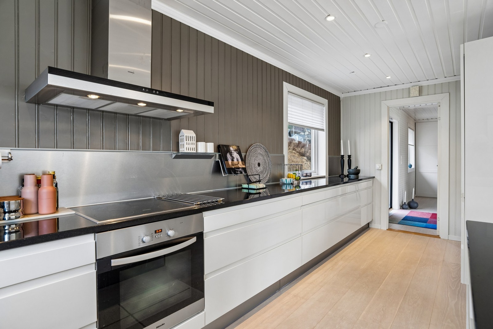 Kjøkkeninnredningen er fra HTH og har glatte fronter og benkeplate av stein. Galleribilde