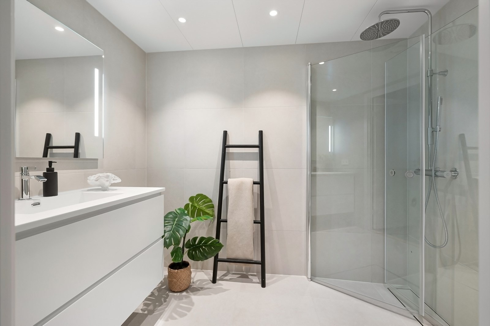 Moderne baderom med regnfallsdusj, store fliser og vask nedfeldt i skuffeløsning Galleribilde