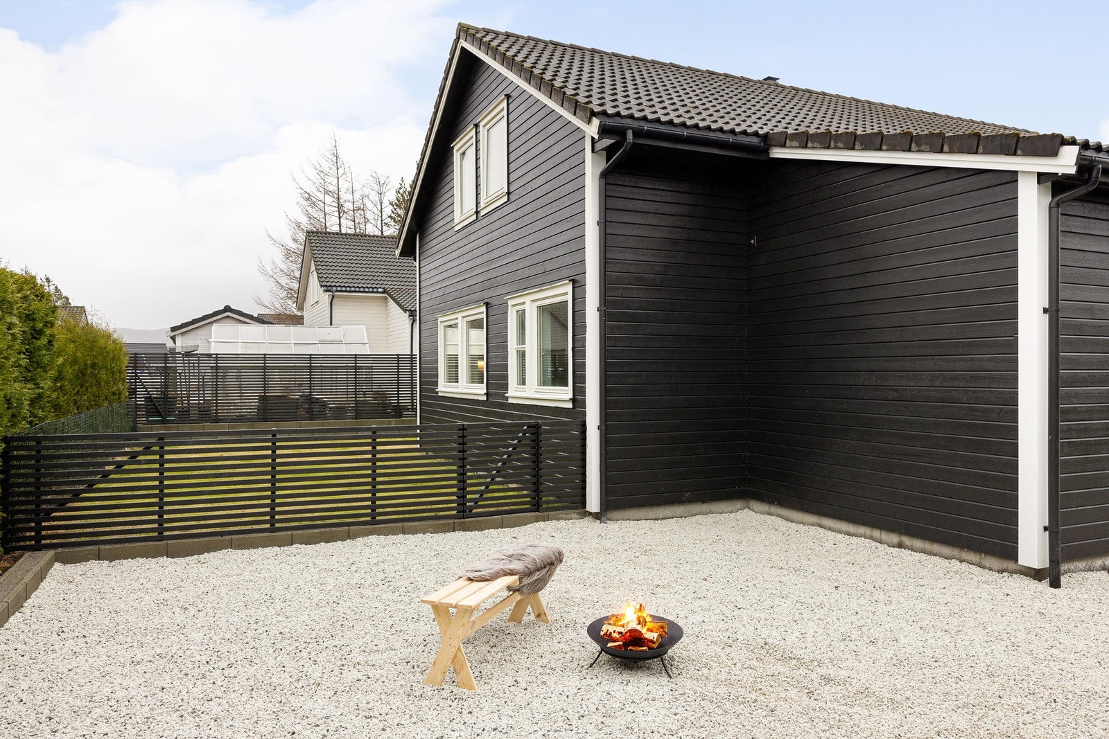 Eiendommen er pent opparbeidet med spilerekkverk rundt hage og terrasse, samt med hvit singel på hele parkeringsplassen. Galleribilde