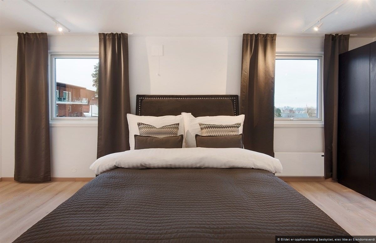 Hovedsoverommet er to soverom som er slått sammen til ett stort, med romslig garderobe og utsikt mot bryggeanlegget og byen. Galleribilde