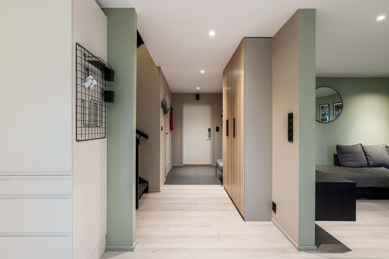 Entréen har tydelig overgang mellom flis og lyst gulv, dempet belysning og god sikt inn mot oppholdsrom. Galleribilde