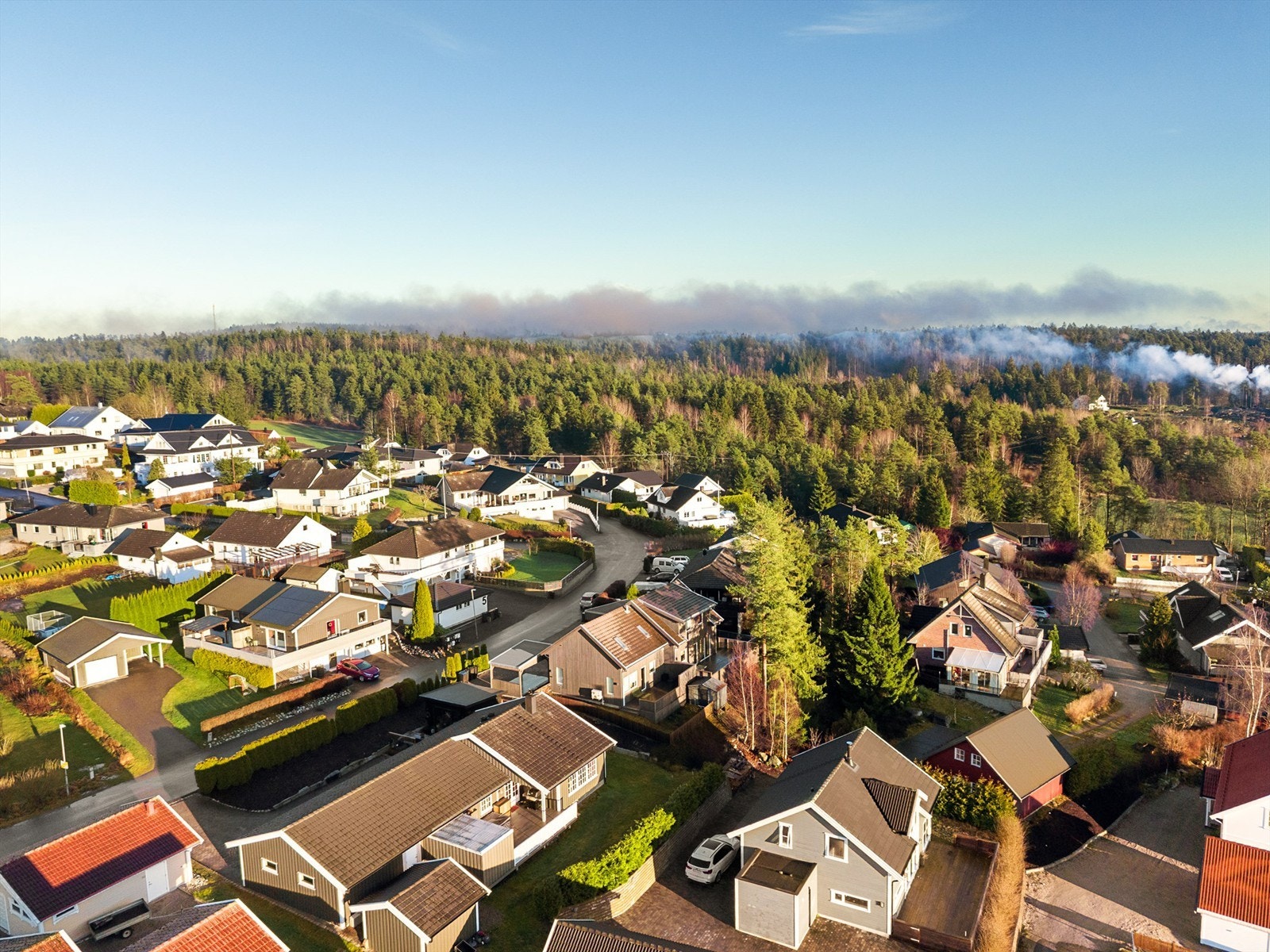 I nabolaget møt du vid utsyn mot grøntdrag i horisonten, lyse hageflater og et rolig, oversiktlig nabolag. Galleribilde