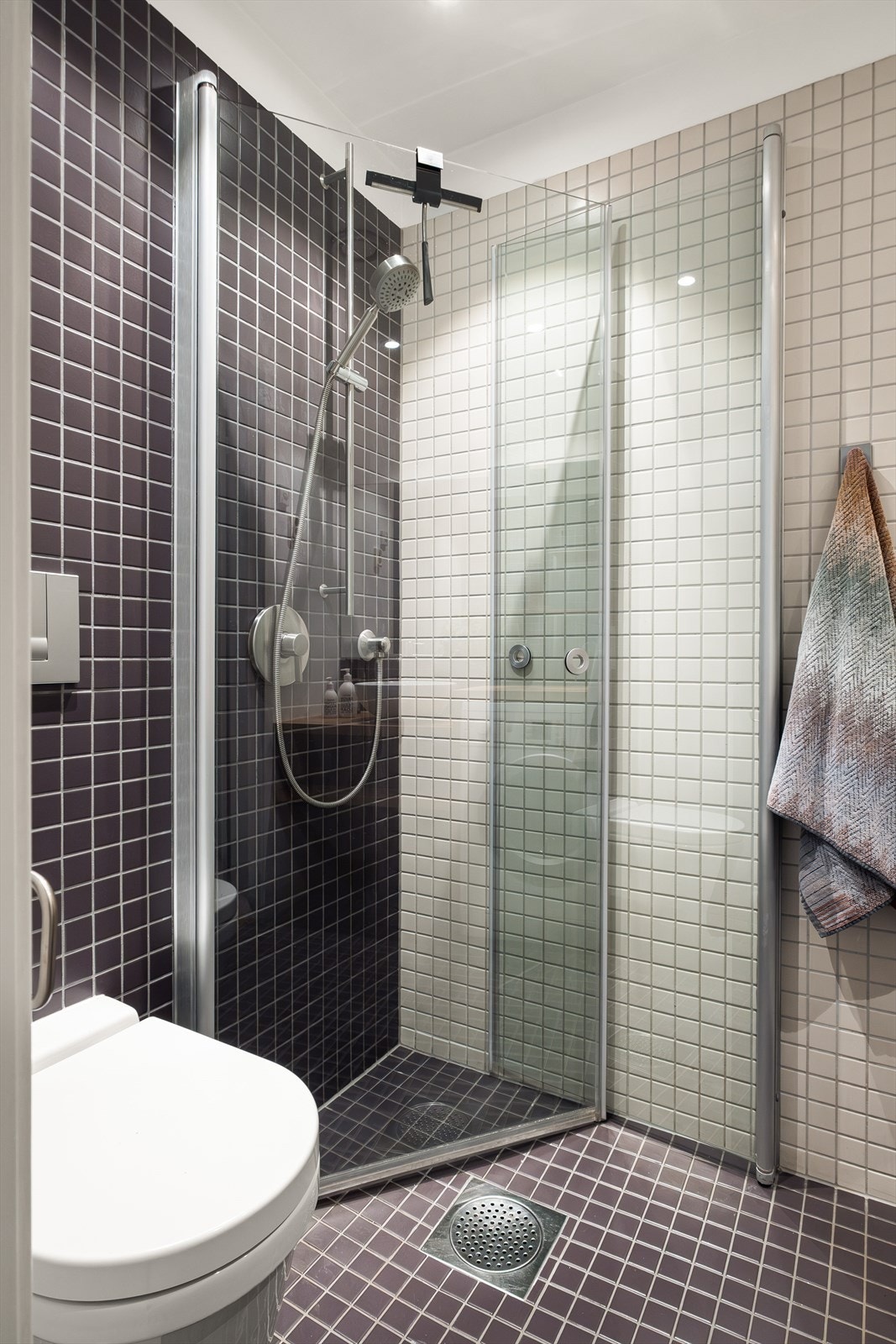 Baderommet er innredet med vegghengt klosett, baderomsinnredning med servant og speil, samt dusjvegger. Galleribilde