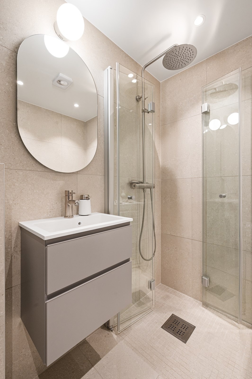 Her er det elektrisk gulvvarme for ekstra komfort, samt et dusjhjørne med svingbare foldedører. Galleribilde