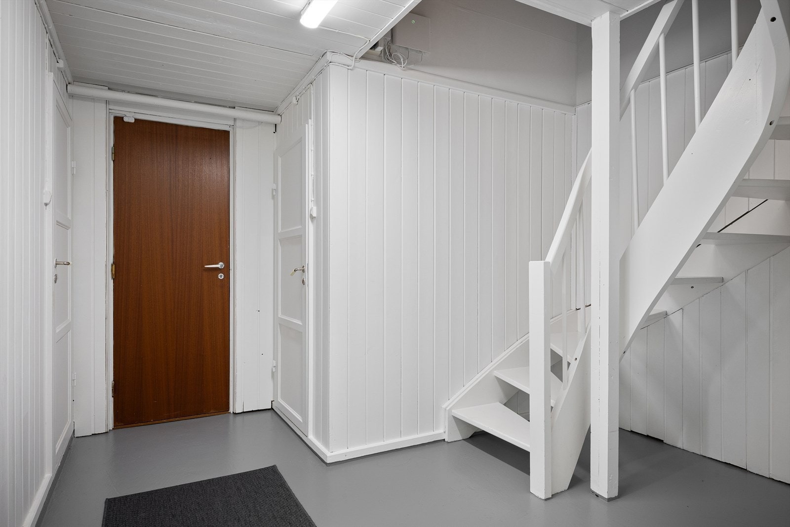 Trapperommet i kjelleren har malte panelvegger og malt betonggulv. Galleribilde