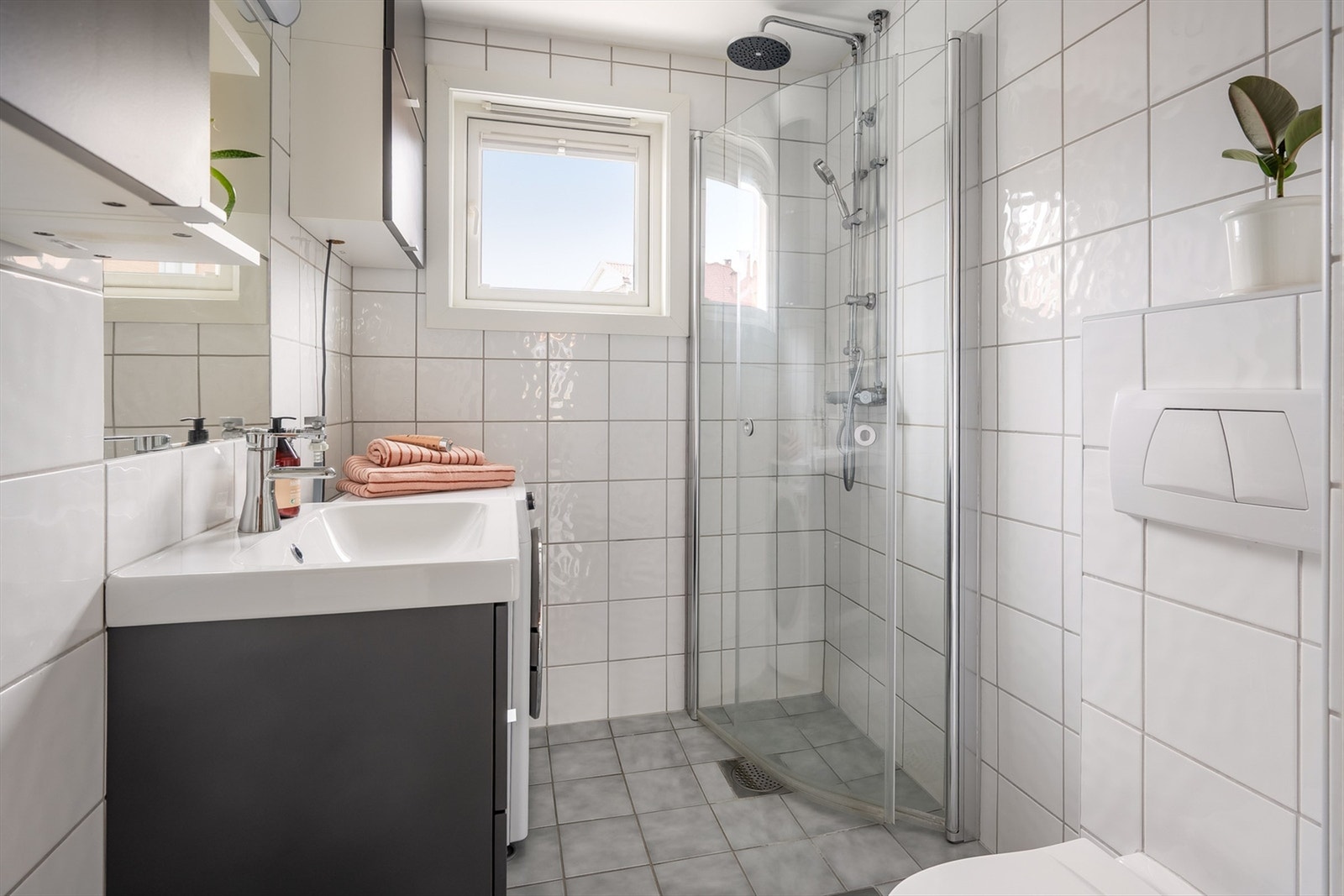 Flislagt baderom med gulvvarme, downlights og opplegg for vaskemaskin Galleribilde