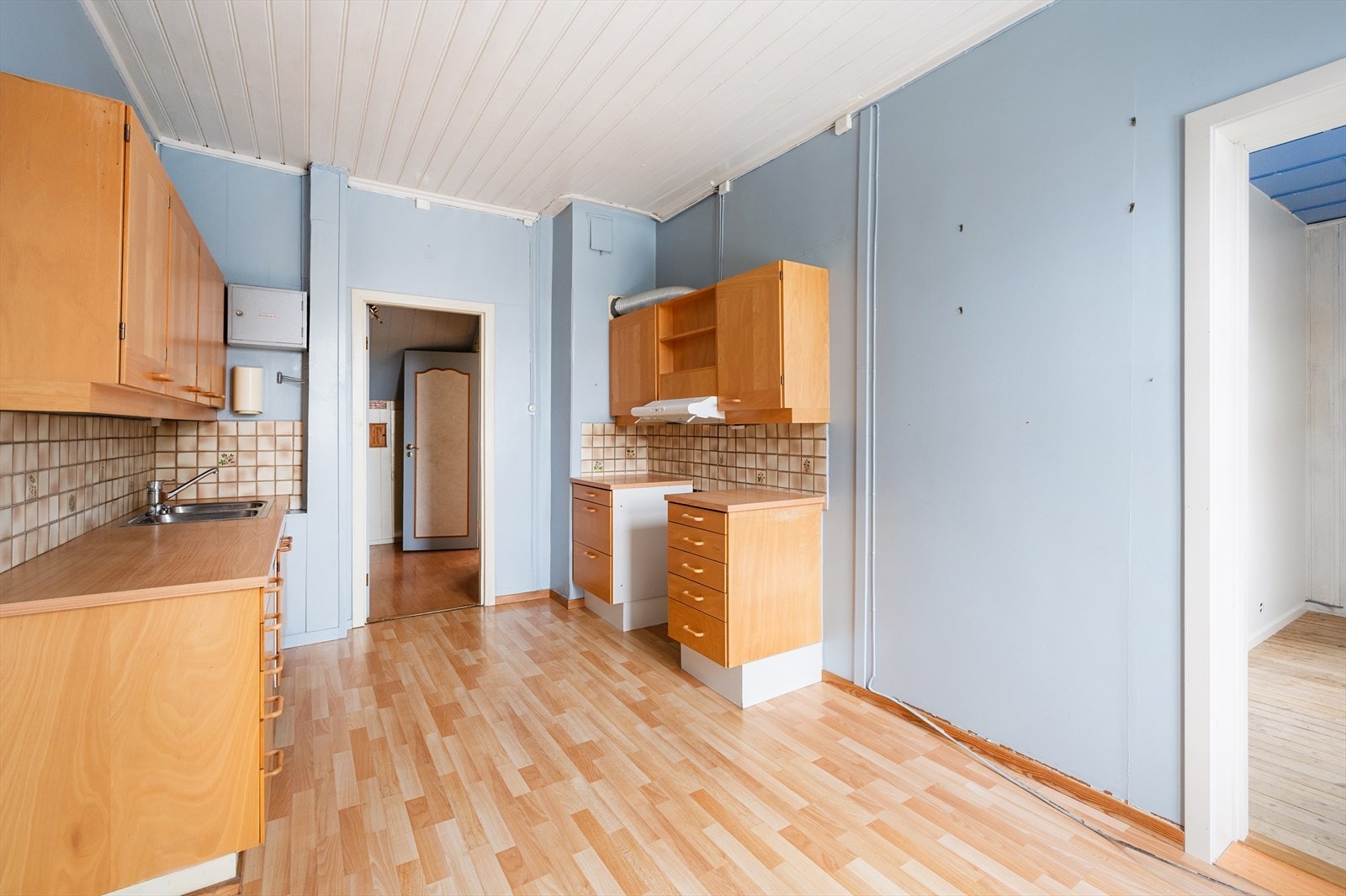 Innredningen har slette fronter og laminat benkeplate med nedfelt oppvaskkum og ettgreps blandebatteri. Det er opplegg for oppvaskmaskin samt mekanisk avtrekk fra ventilator. Kjøkkenet mangler egen ventilasjon, og oppussing må forventes. Galleribilde