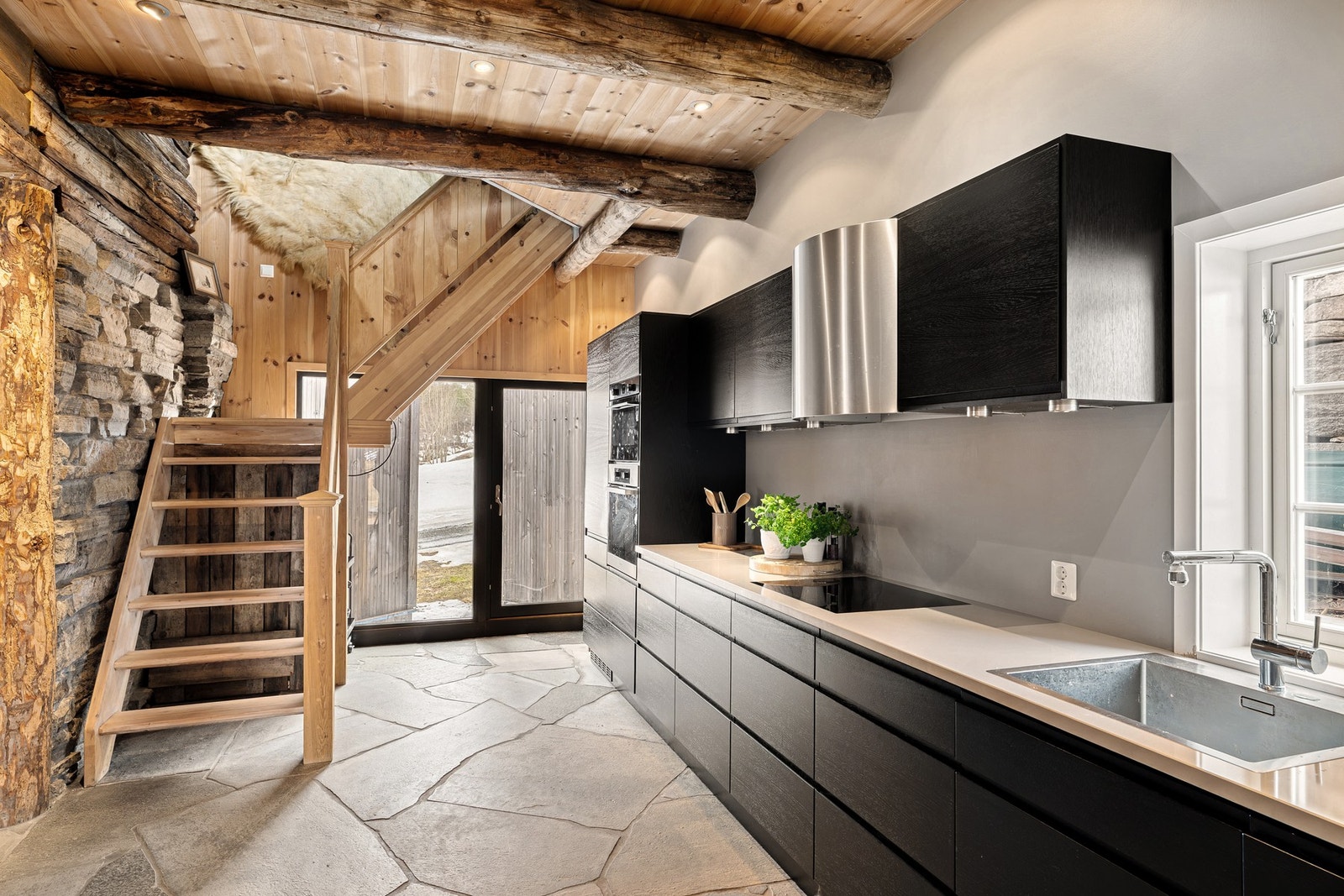 Moderne kjøkken i stilig kontrast til tømmer og oppdalsskifer. Galleribilde