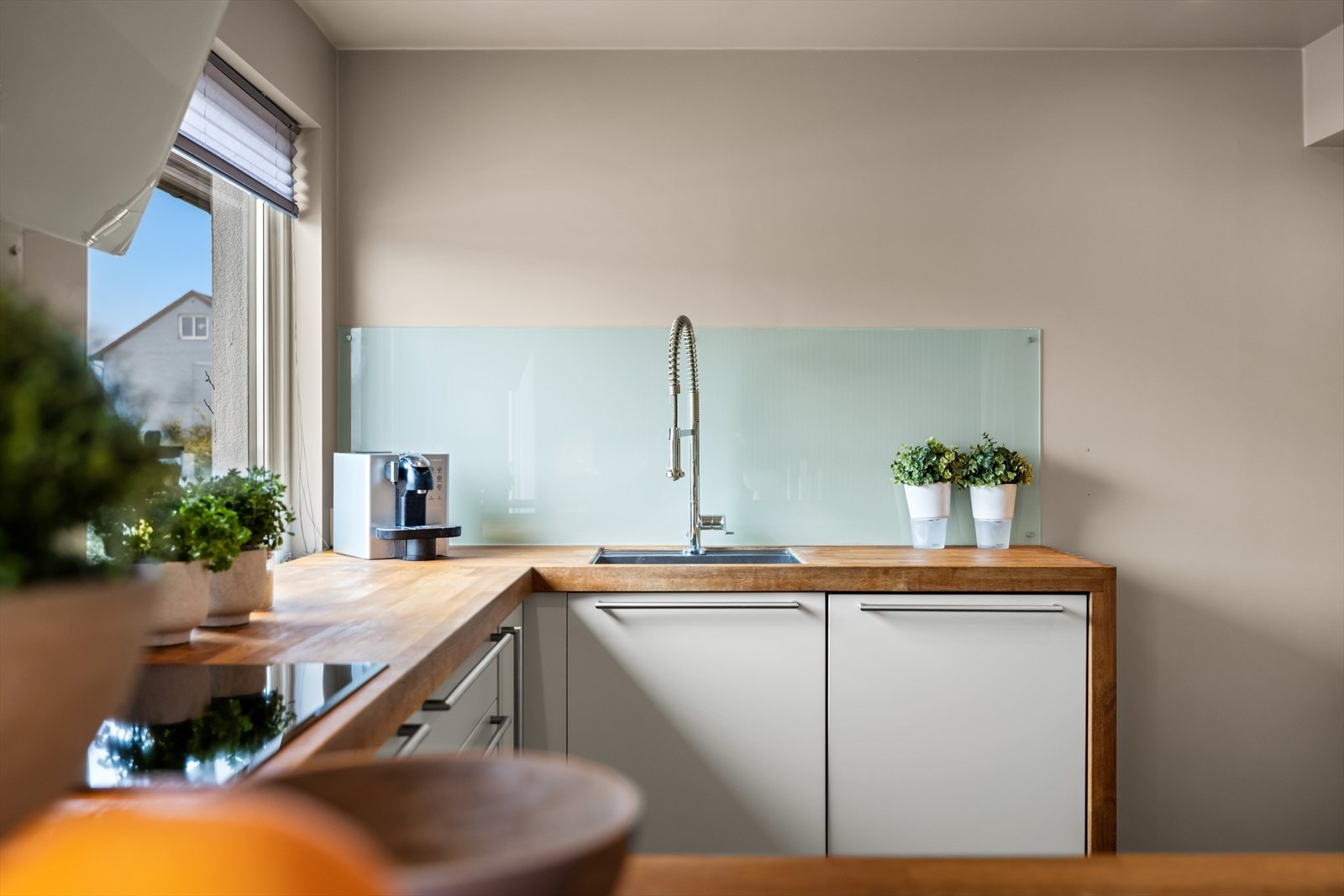 Det er glatte og folierte fronter i hvitt og eik, samt heltre eik benkeplate. Galleribilde