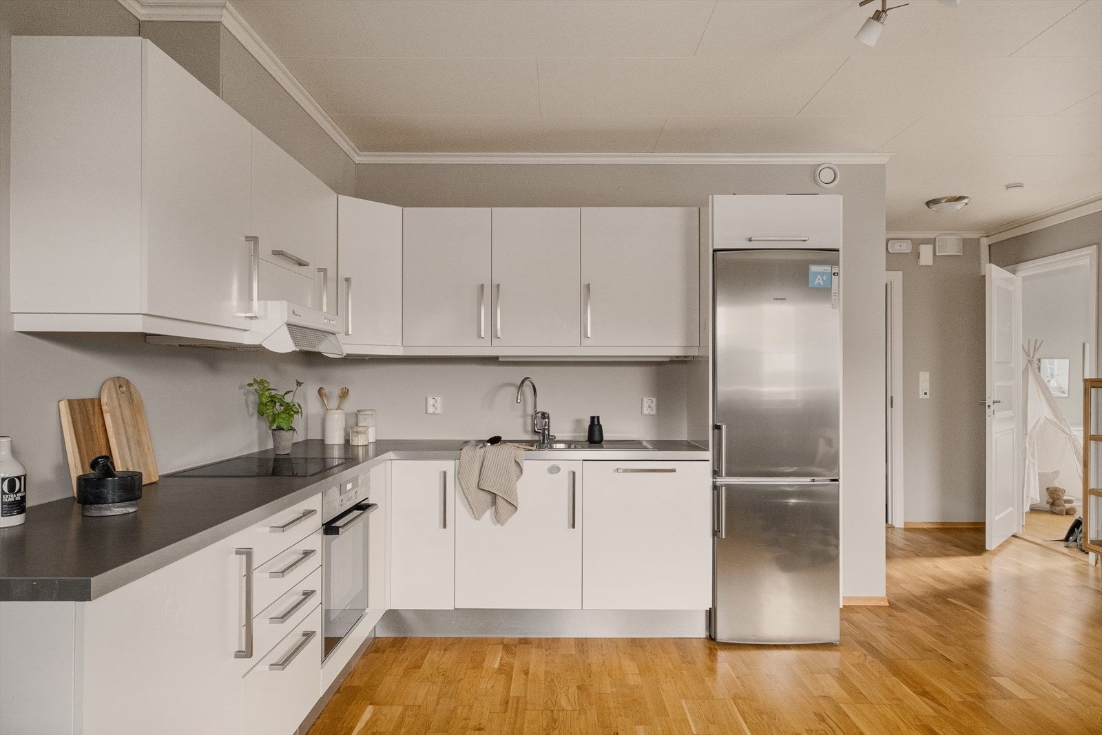 - Tidløs kjøkkeninnredning med slette fronter og benkeplate i laminat - Galleribilde