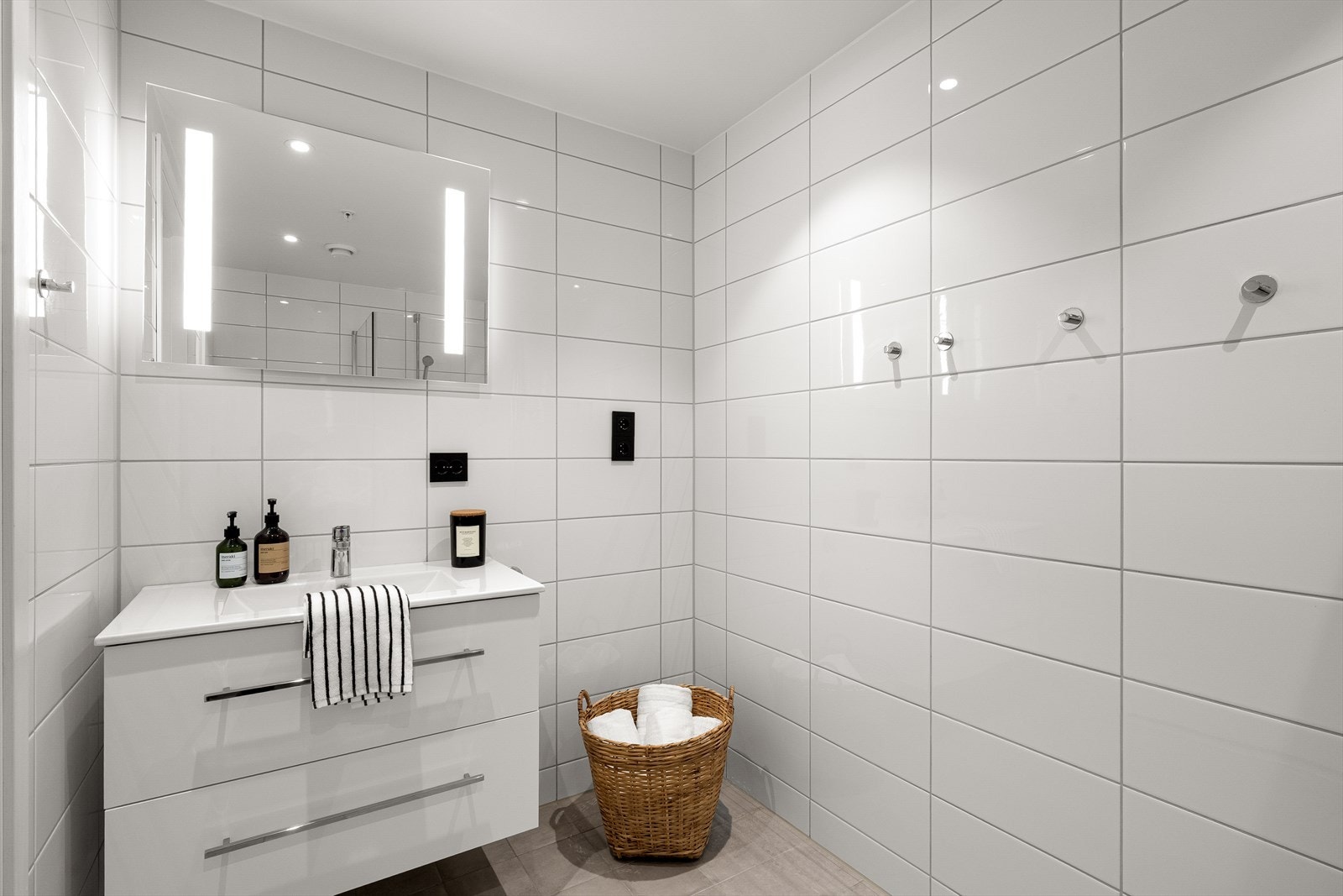 Badet fremstår lyst og praktisk, og er utstyrt med wc, dusjhjørne og gulvvarme for ekstra komfort. Galleribilde