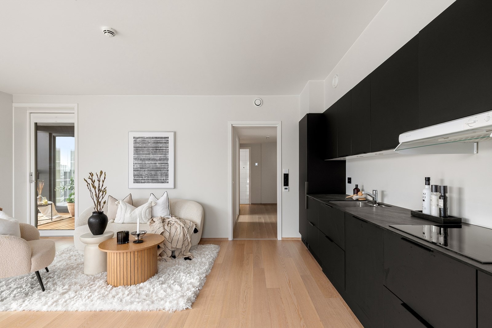 Funksjonelt kjøkken med stilrene overflater og plass til spisebord. Et praktisk og hyggelig rom i hjertet av hjemmet. Galleribilde