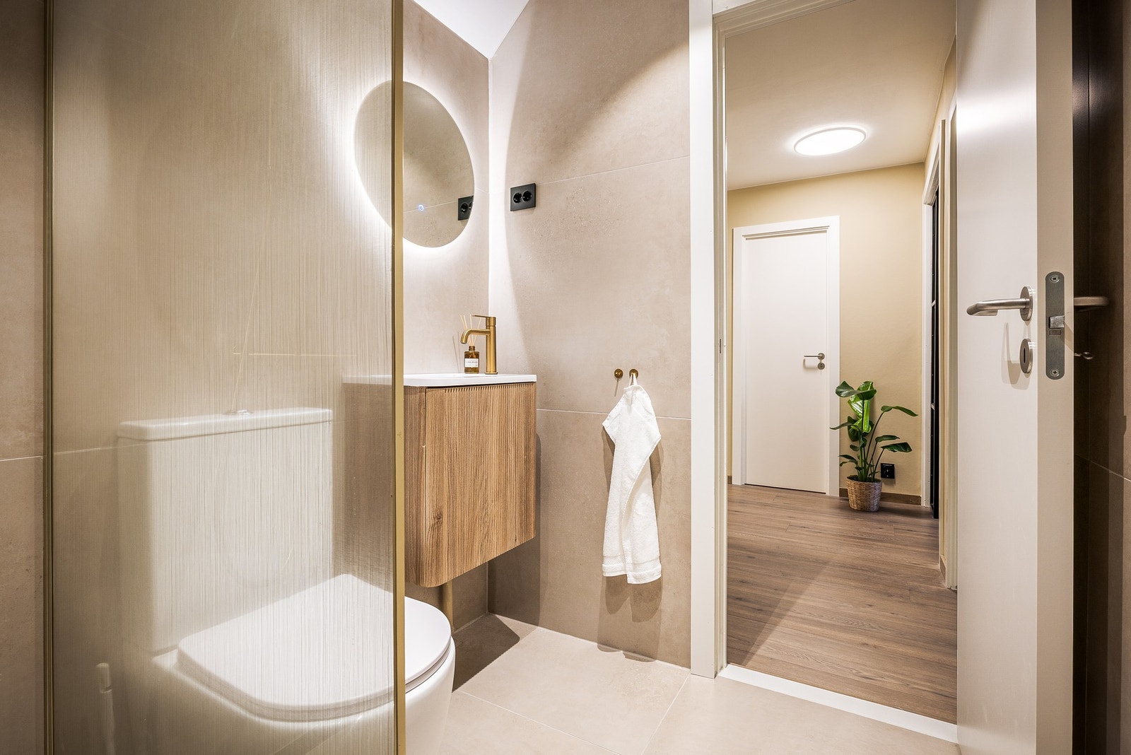 Badet er innredet med toalett, dusj med glass nisje, servant med møblement, speil og belysning.
Det er elektriske varmekabler i gulvet og ventilasjon via elektrisk avtrekksvifte. Galleribilde