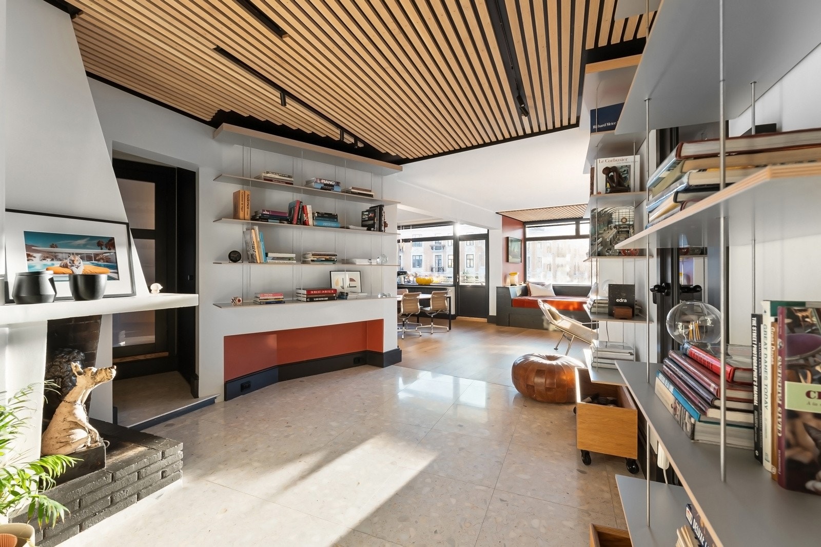 De hvite terrazzo-flisene i entréen fortsetter sømløst inn i biblioteket. Peisen tilfører varme og karakter til rommet. Galleribilde