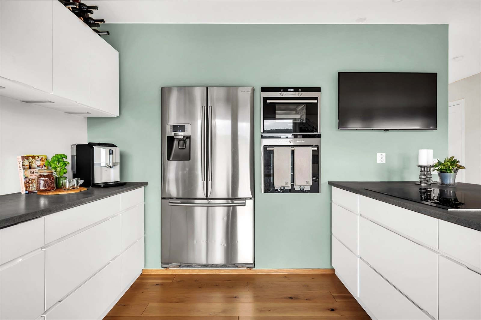 Lekkert og tidløst kjøkken med integrerte hvitevarer som induksjon koketopp, innfelt stekeovn og dampeovn, fransk kjøleskap/fryser (ekstra bredt) og oppvaskmaskin. Galleribilde