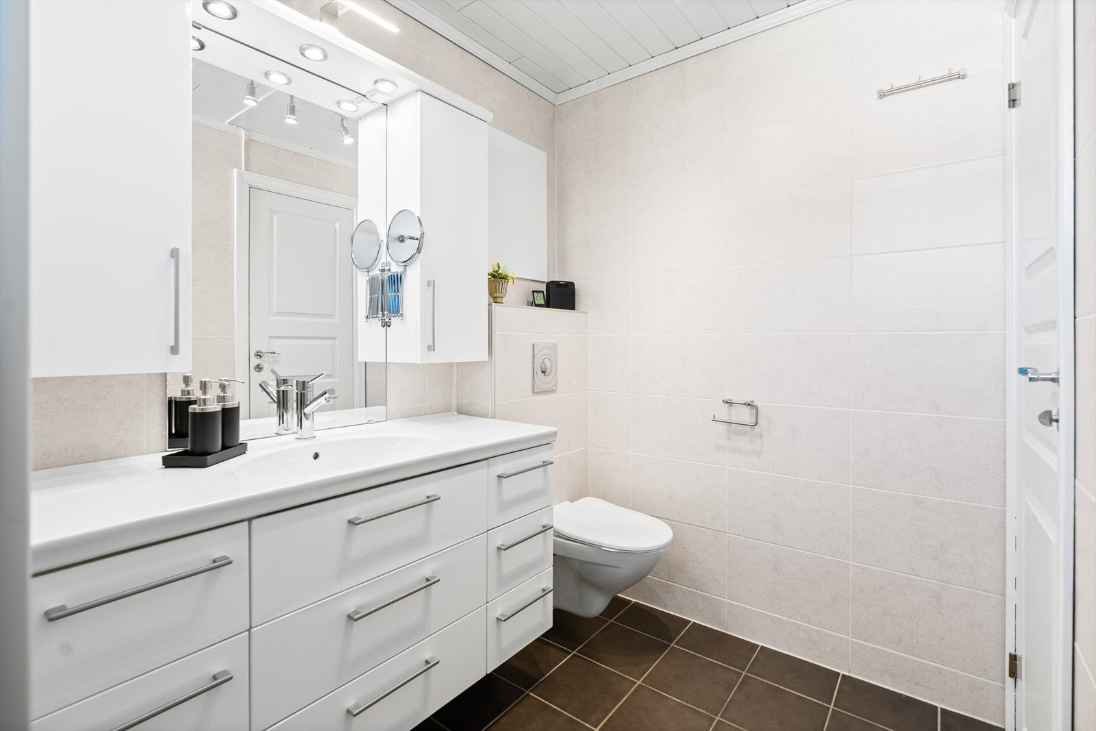 Det er oppbevaringsplass i benkeskapet med glatte fronter, samt speil mellom overskap. Galleribilde