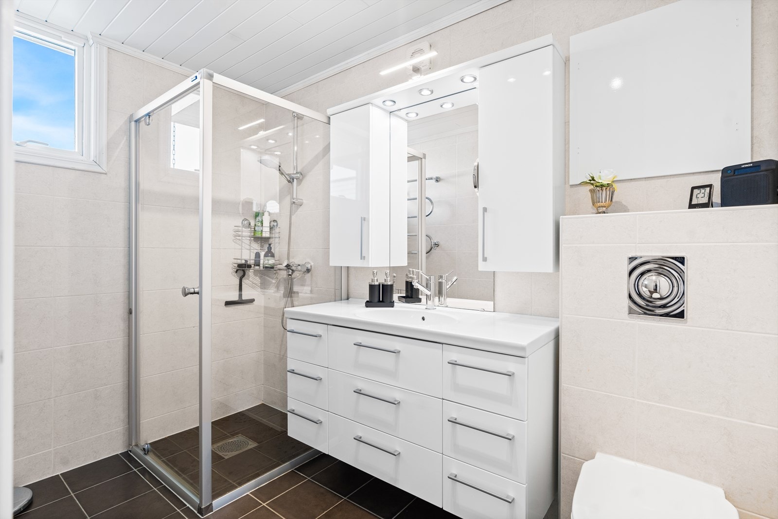 Badet er ifølge en tidligere salgsannonse fra 2008. Gulv og vegger er flislagte. Rommet er utstyrt med dusj på gulv med dører i herdet glass, veggfestet klosett med innebygget sisterne samt en servant med benkeskap. Galleribilde