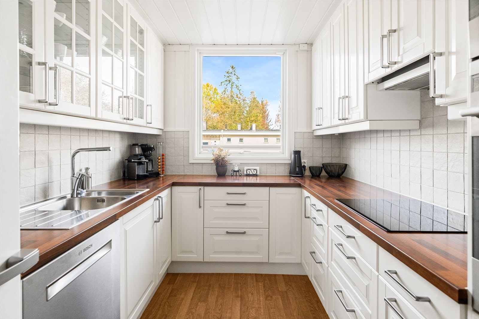 Det er belysning under overskapene samt fliser på veggen over benkeskapet. Galleribilde