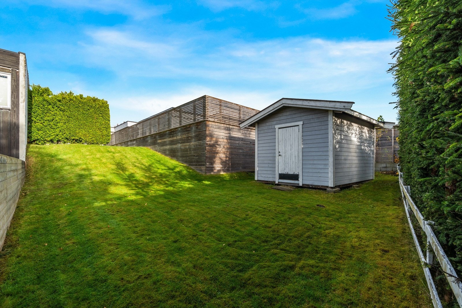 Det er utgang til stor terrasse på husets bakside, samt tilgang til en skjermet inngjerdet hage. I hagen er det gressplen, hekk og øvrig beplantning, samt tilgang til utebod. Galleribilde