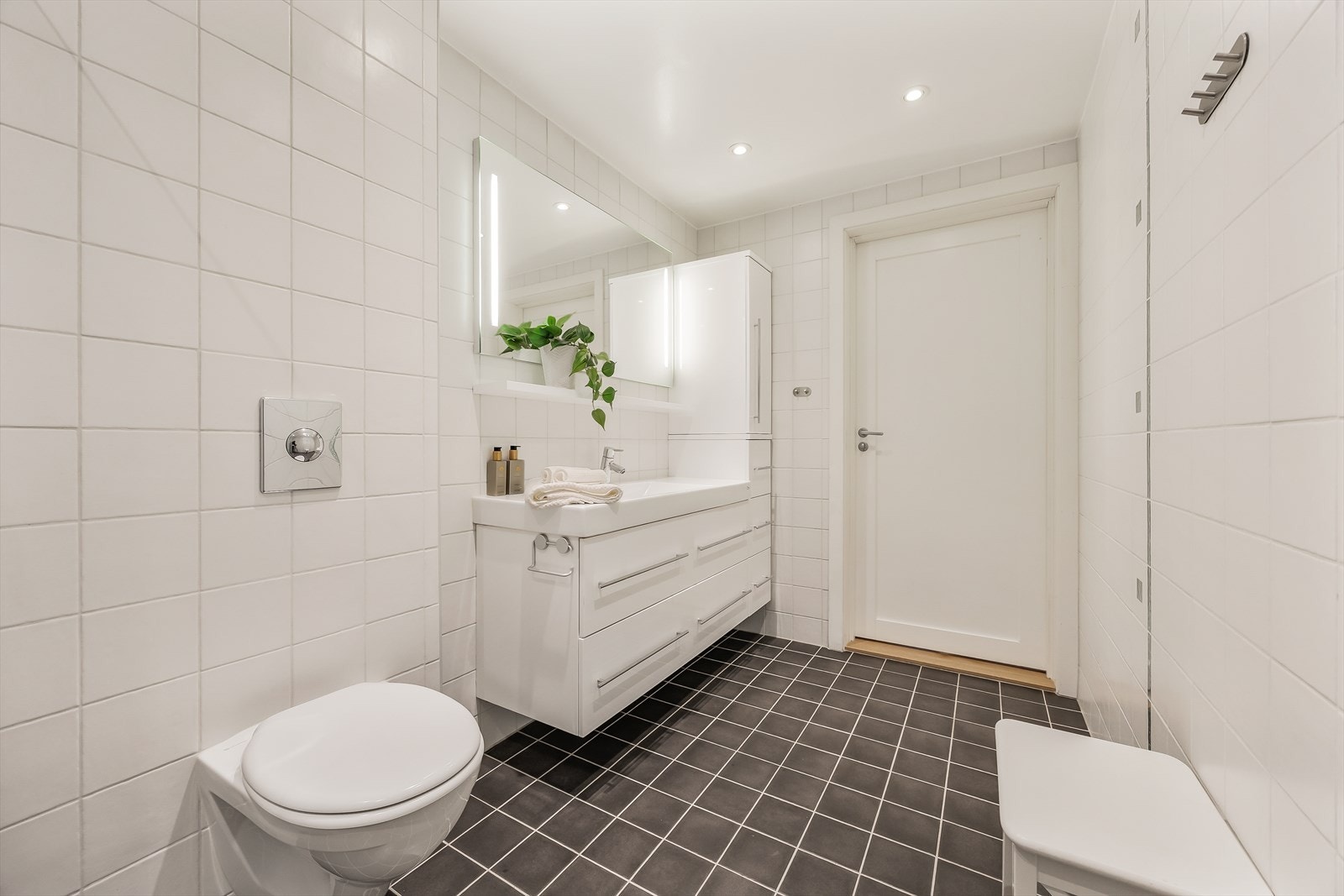 Badet er innredet med vegghengt klosett, formstøpt servant og speil med belysning. Galleribilde