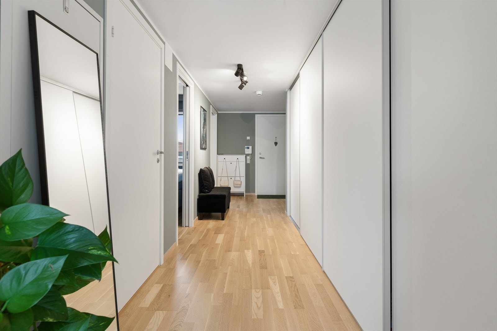 Romslig entré med parkettgulv og oppbevaringsplass i en stor garderobeløsning. Galleribilde