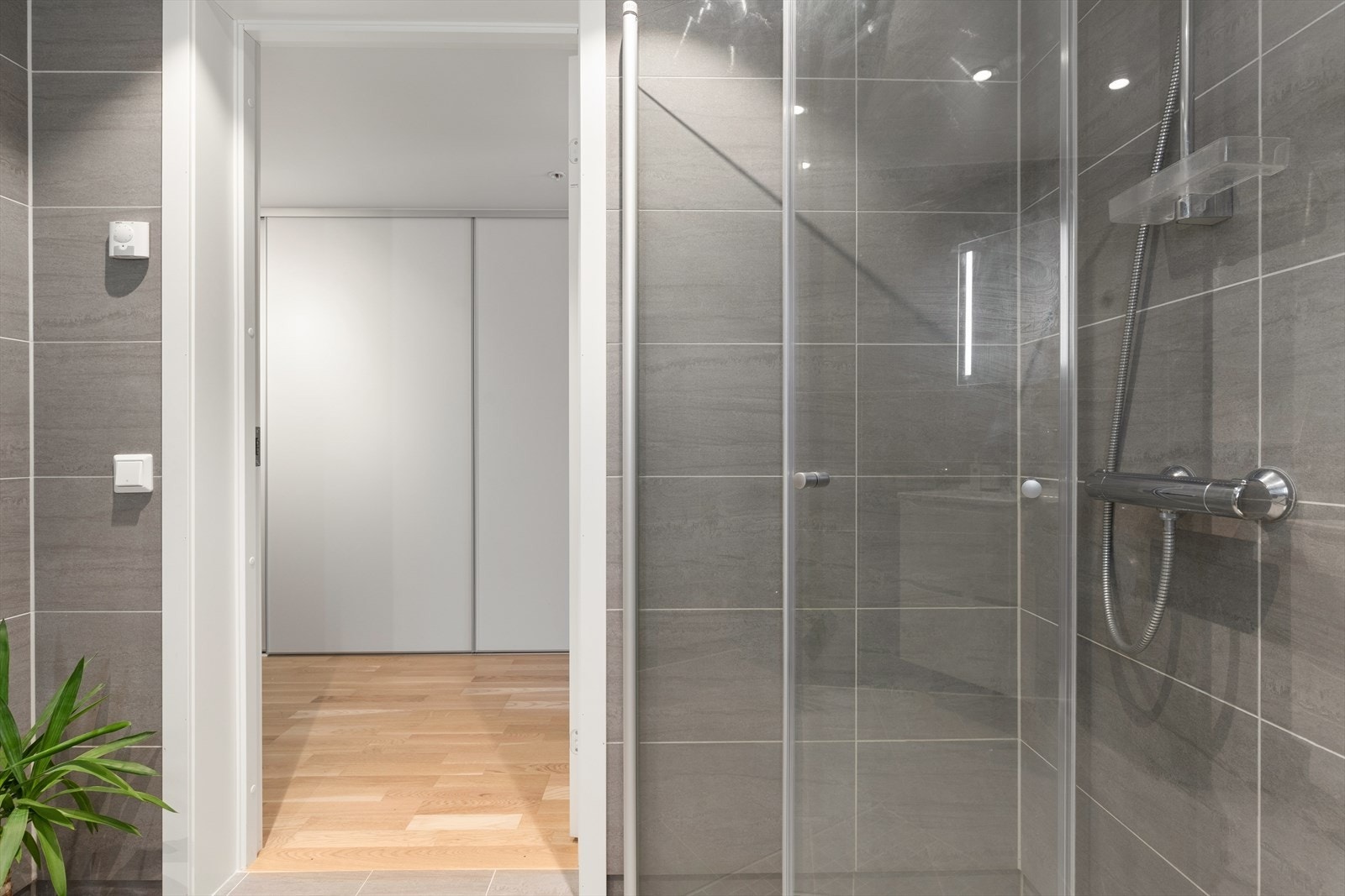 Dusjhjørne med praktiske, innsvingbare glassdører. Også her er det vannbåren gulvvarme. Galleribilde