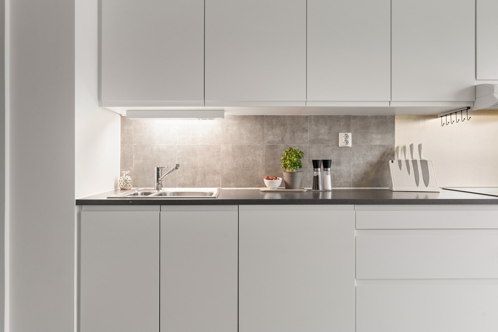 Benkeplaten er i laminat og det er festet en sprutskjerm på veggen i kokesonen, samt flislignende plater på resten av bakveggen for beskyttelse. Galleribilde