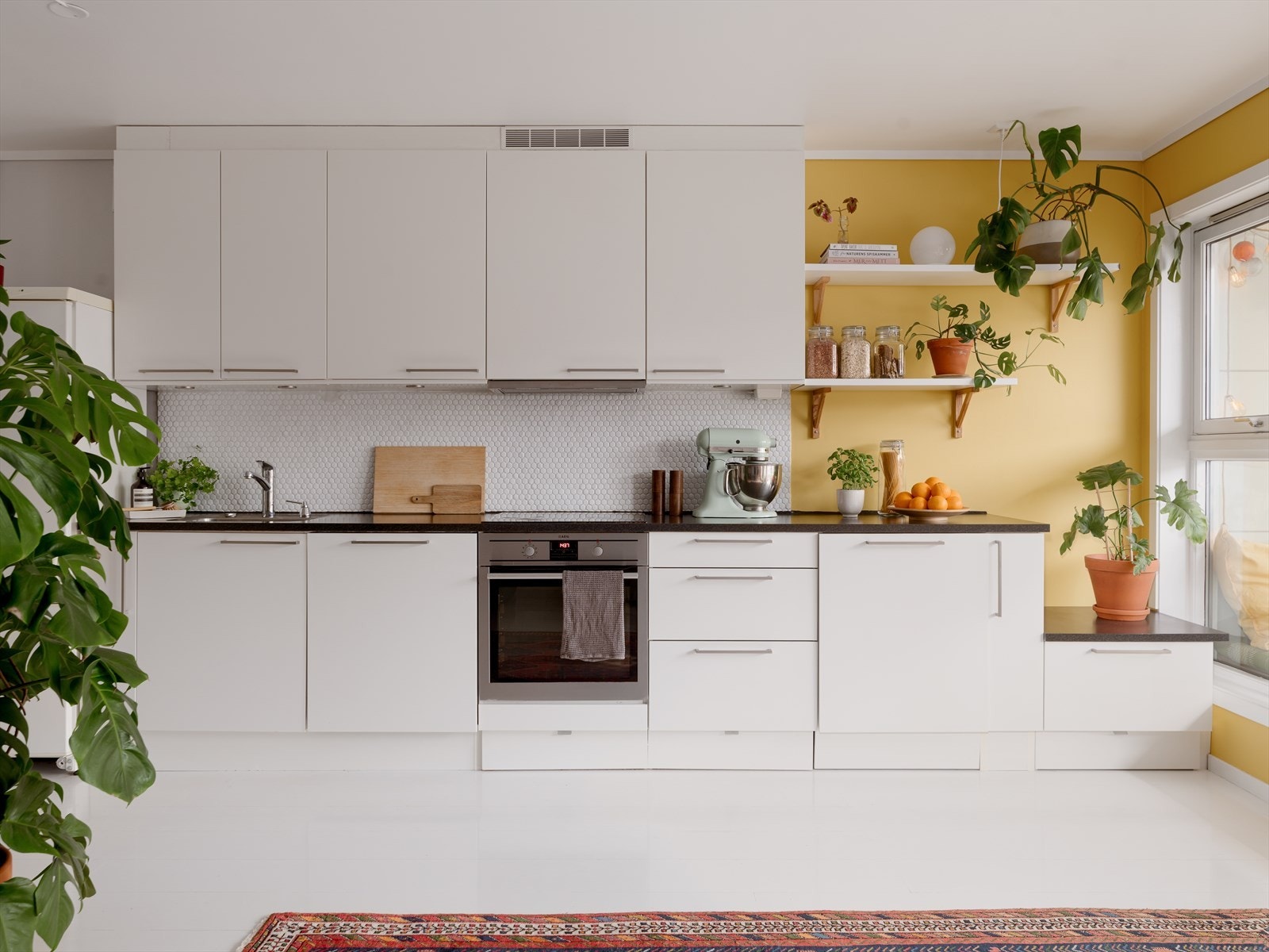 Det delikate kjøkkenet er innredet med hvite, slette fronter og laminert benkeplate. Galleribilde