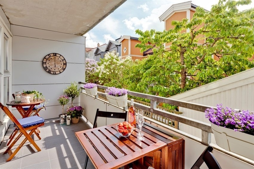 På sommerstid vender balkongen mot en grønn oase, med både morelltre, japansk rødlønn og klatrehortensia. Bilde fra tidligere eier. Galleribilde