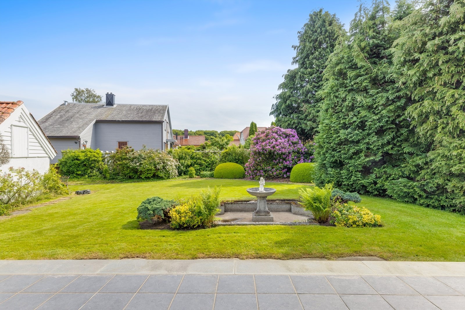Hagen har klassiske elementer som prydbusker og en sentral fontene. Galleribilde