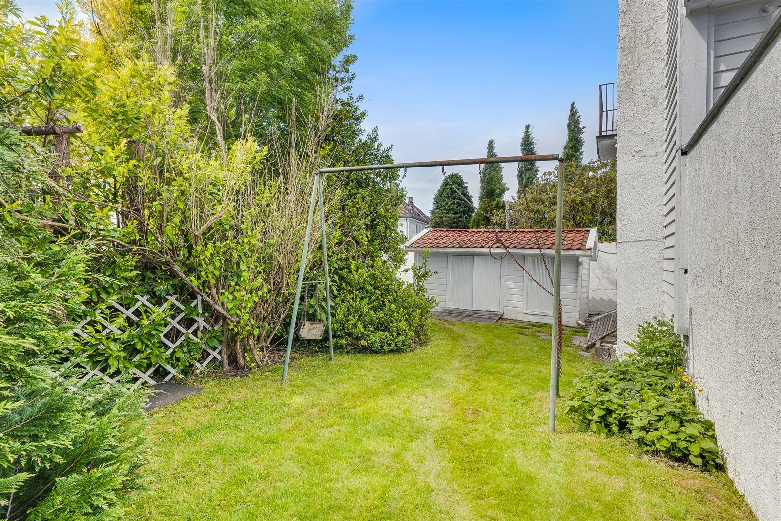 Et hjørne av hagen med plass for lekestativ og utendørsaktiviteter. Galleribilde